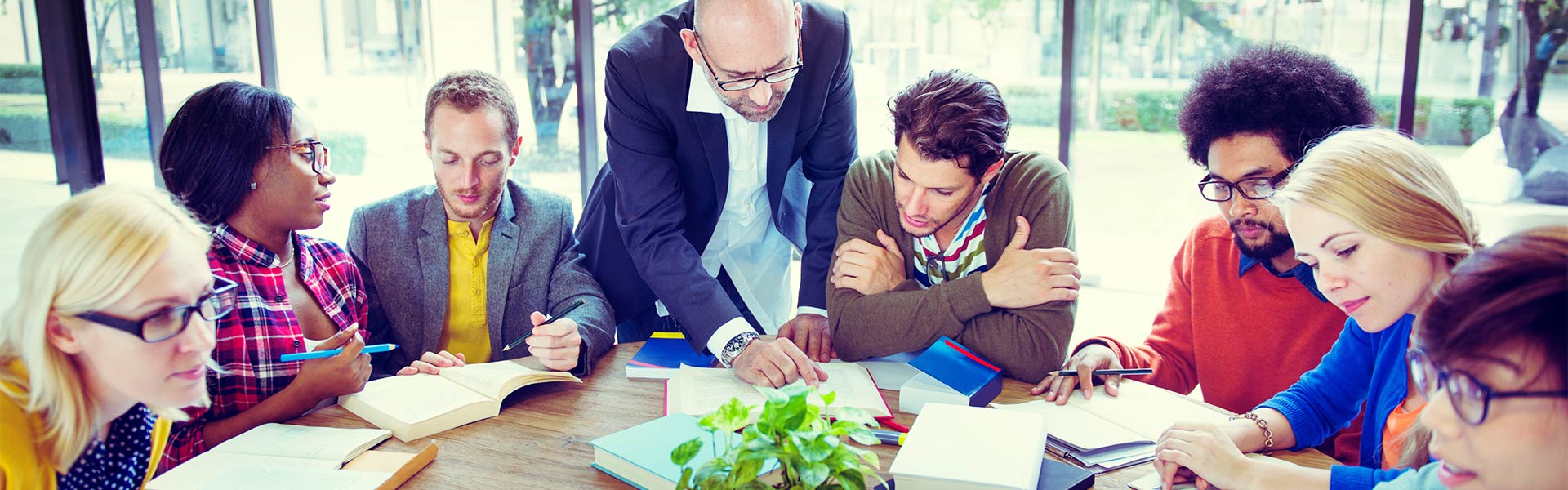 Man in suit teaching a group of seven people