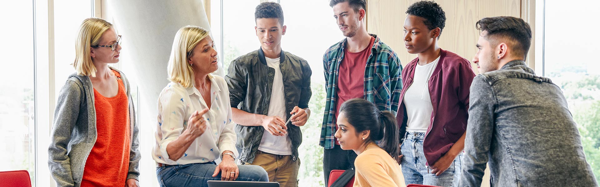 Woman speaking to a group of college aged students