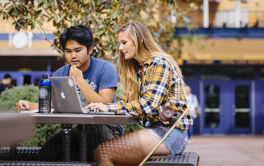 Students sitting by a tree