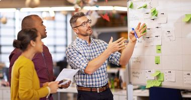 Project manager reviewing whiteboard
